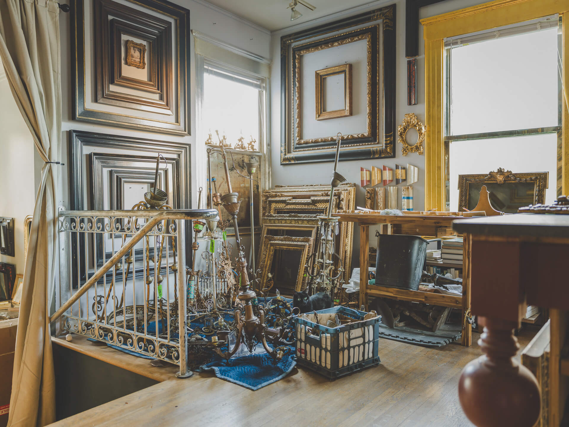 Interior of the Aedicule workshop filled with ornate picture frames, tools and gilding materials.