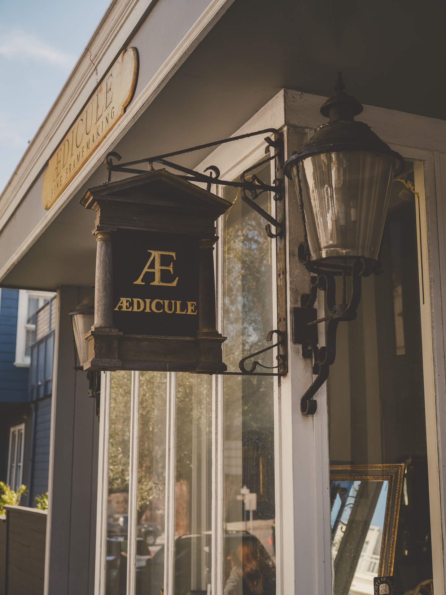Aedicule hanging sign and lantern outside the San Francisco framing and gilding studio