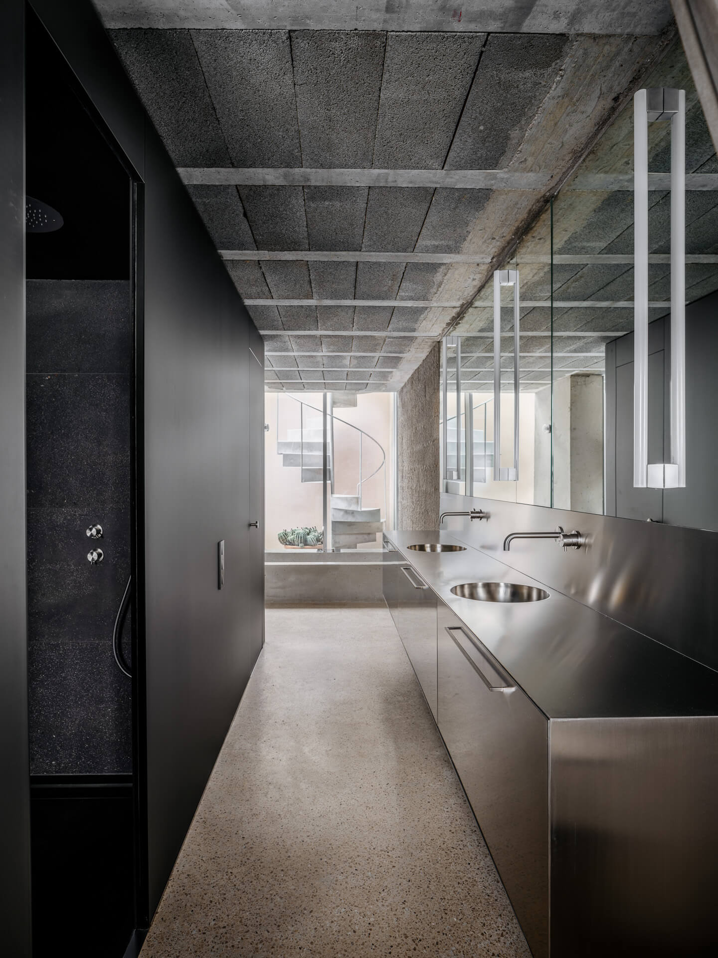 Narrow bathroom with dark walls, stainless steel vanity, and an exposed concrete ceiling.