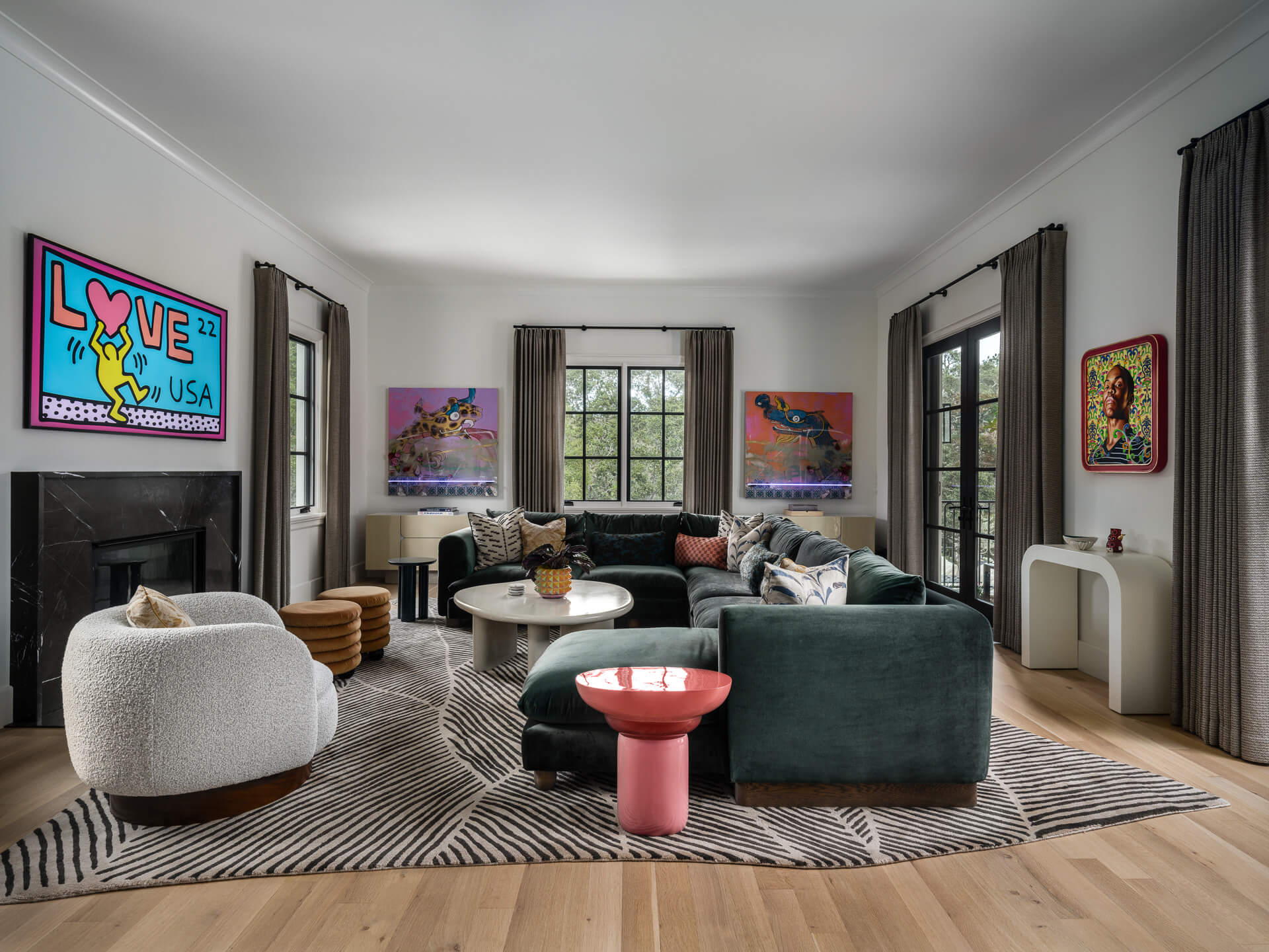 Colorful living room with green sofa, white lounge chair, bold artwork, and a small pink side table.