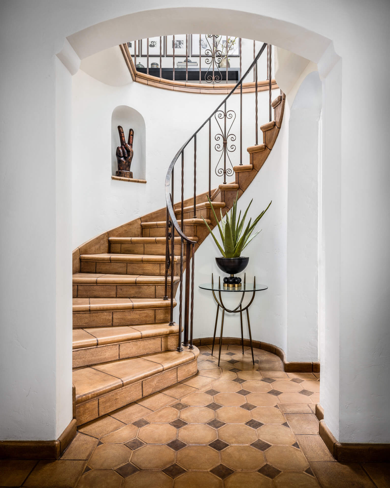 Curved terracotta staircase with wrought-iron railing in a Miracle Mile Los Angeles home