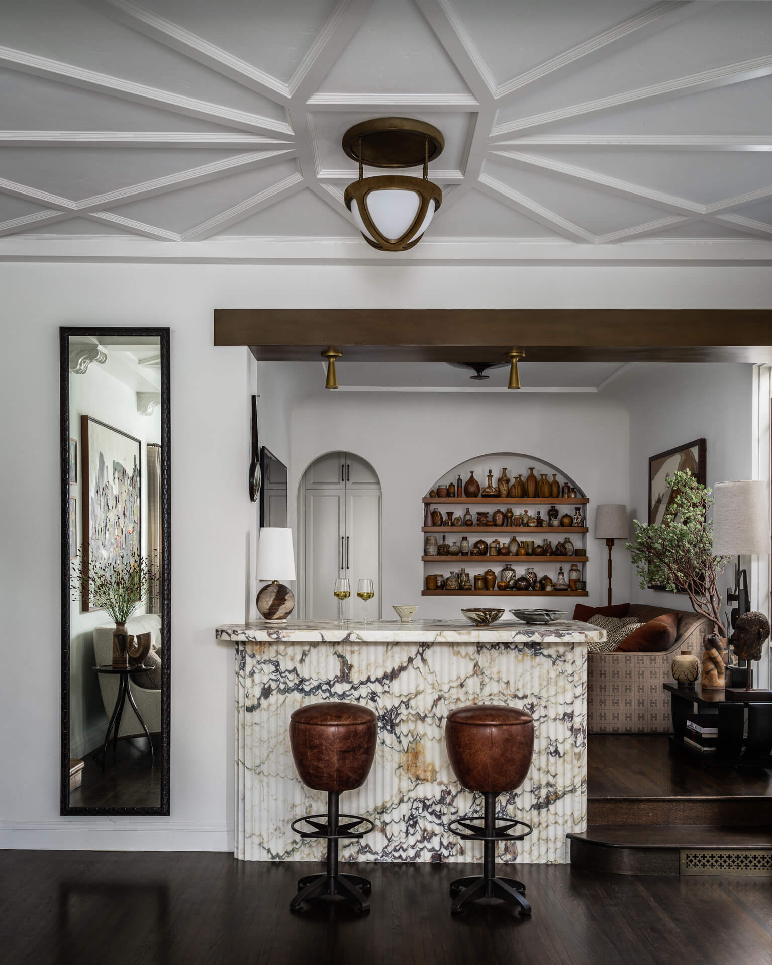 Marble home bar with leather stools, arched niches and display shelves