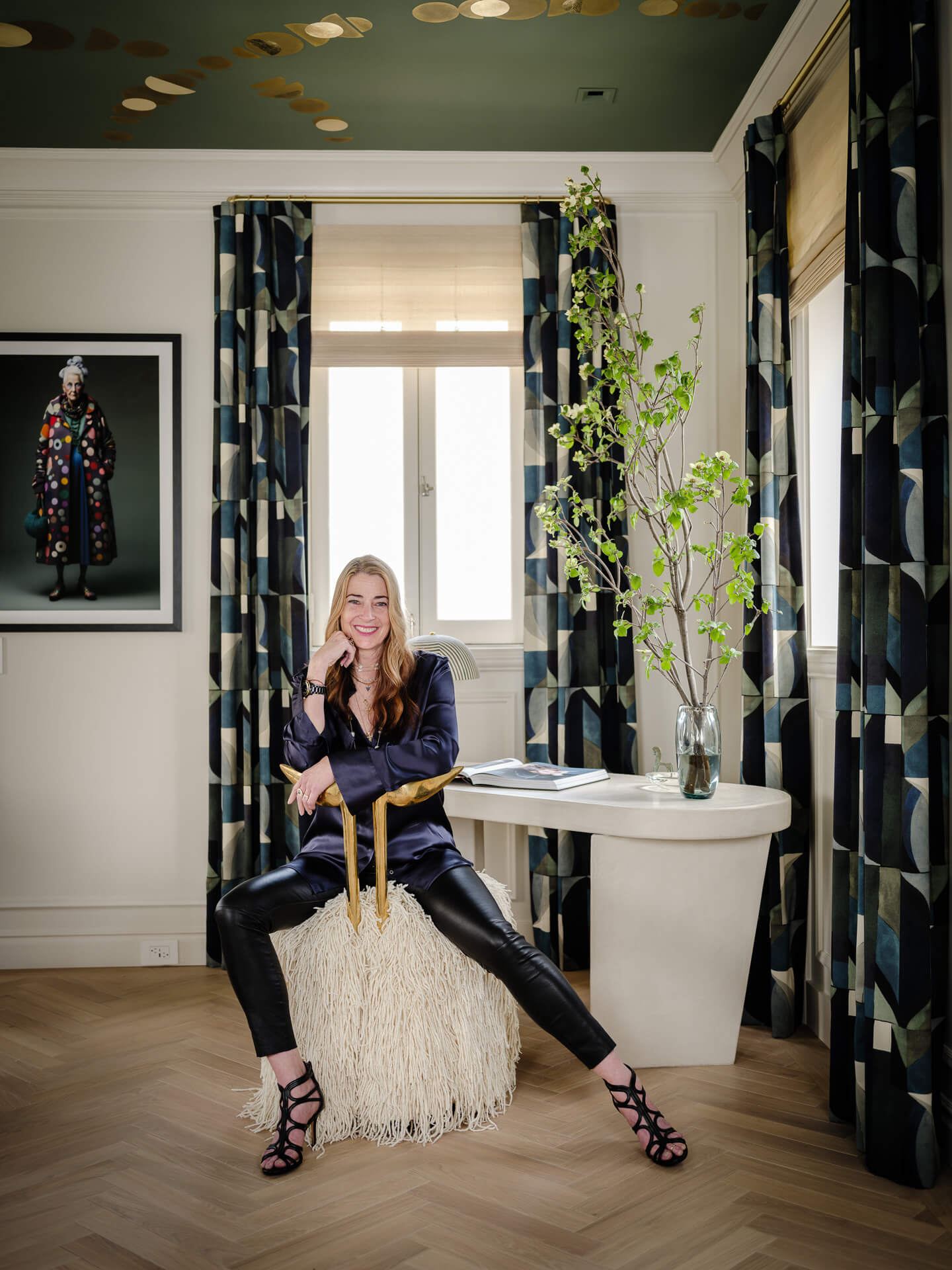 Tineke Triggs seated in a graphic interior accented with greenery.